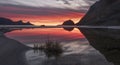 sunset reflected in the water on a paradise beach Haukland with white sand, and mountains the Lofoten Islands in polar Norway