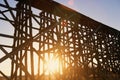 Red sunset shining through scaffolding of elevated train bridge Royalty Free Stock Photo
