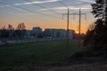 red sunset with sun setting down behind large electricity power