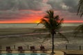 Red sunset on a tropical beach in a swimming pool resort Royalty Free Stock Photo