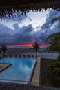 Red sunset on a tropical beach in a swimming pool resort Royalty Free Stock Photo