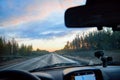 Red sunset view with shining sun from the car front window. Driving car during sunset concept. View on nature landscape and a road Royalty Free Stock Photo