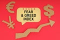 On the red surface there are money symbols, an arrow and a sign with the inscription - Fear and Greed Index