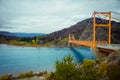 Red suspension bridge over the water runoff of General Carrera Lake, near Lake Bertrand, Puerto Tranquilo, Chile Chico, Aysen, Royalty Free Stock Photo