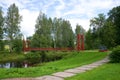 The red suspension bridge through the river Tosna in the cloudy July afternoon. Estate Maryino, Leningrad region
