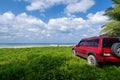 Red SUV 4x4 car on the mountain with Summer sea and blue sky background,Copy space for summer text and travel transportation Royalty Free Stock Photo