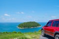 Red SUV 4x4 car on the mountain with Summer sea and small island background of free space for summer text and travel Royalty Free Stock Photo