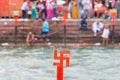 Red swastika cross on the Ganges River at Haridwar, India, sacred city for Hindu Religion. Pilgrims bathing on the ghats. Royalty Free Stock Photo