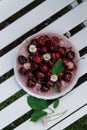 Red sweet cherries on a plate on a white garden bench Royalty Free Stock Photo