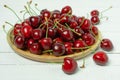 Red sweet cherry berries on a plate on white wooden table, close up Royalty Free Stock Photo