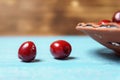 Red sweet cherry in a clay plate on a turquoise wooden table