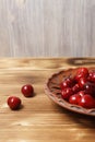 Red sweet cherry in a clay plate on a wooden table