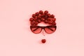 Red sweet cherry laid out in image of woman in sunglasses with lips on pink background, coral toned. Concept youth, beauty, Royalty Free Stock Photo