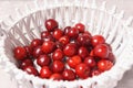 Red sweet cherry in a white basket on a cream background