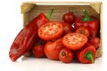 Red sweet peppers and tomatoes in a wooden crate Royalty Free Stock Photo