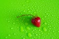 Red sweet ripe strawberry berry on green matte background with water drops Royalty Free Stock Photo