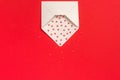 Red Sweets sprinkles candy hearts fly out of white paper envelope on red background. Top view Copy space for text. Concept Royalty Free Stock Photo