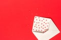 Red Sweets sprinkles candy hearts fly out of white paper envelope on red background. Top view Copy space for text. Concept Royalty Free Stock Photo