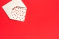 Red Sweets sprinkles candy hearts fly out of white paper envelope on red background. Top view Copy space for text. Concept Royalty Free Stock Photo