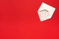 Red Sweets sprinkles candy hearts fly out of white paper envelope on red background. Top view Copy space for text. Concept Royalty Free Stock Photo