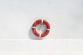 Red swimming pool lifebuoy on the white wall background. Minimalistic wallpaper Royalty Free Stock Photo