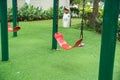 Red swing on children playground in city Royalty Free Stock Photo