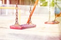 Set of red chain swings on modern kids playground Royalty Free Stock Photo