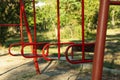Red swings in city park in bright sunny morning Royalty Free Stock Photo