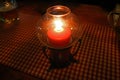 Red table candle on a stripes cloth