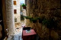 Red table of a street cafe in Kotor between narrow walls