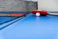 Red table tennis paddle white ball and a net Royalty Free Stock Photo