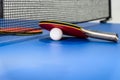 Red table tennis paddle white ball and a net Royalty Free Stock Photo