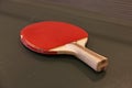 A red table tennis racket on a green ping pong table Royalty Free Stock Photo