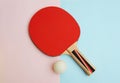 Red table tennis racket and ping pong ball on pink blue Royalty Free Stock Photo