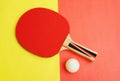 Red table tennis racket and ping pong ball on yellow red Royalty Free Stock Photo