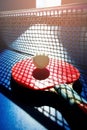 A red table tennis racket and a white ball lie on the surface of the table next to the net. Sports game Royalty Free Stock Photo