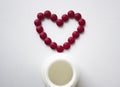The red tablets are arranged in the shape of a heart. Red heart pills with a plastic jar. Royalty Free Stock Photo