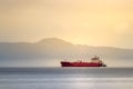 A red tanker ship sailing at high seas in the Bering sea at sunset