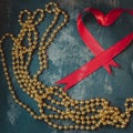 Red tape with gold beads on old background Royalty Free Stock Photo