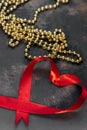 Red tape with gold beads on old background Royalty Free Stock Photo