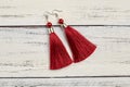 Red tassel earrings on white background