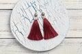 Red tassel earrings on white background
