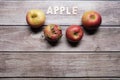 Red tasty apples fruits on a wooden table with apple word written on wood