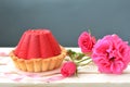 Red, tasty cake with chocolate filling and rose bush on grey background Royalty Free Stock Photo