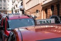 Red taxi car roof sign at day. Cab on the street. Vehicles in line, parked