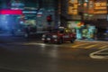 Red taxi rushing in the streest of Hong Kong at night with moti
