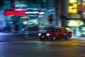 Red taxi rushing in the streest of Hong Kong at night with moti