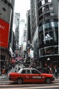 Red taxi waiting on a crosswalk in Hong Kong Island in China