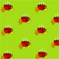 Red tea cup with orange and yellow autumn leaves on a green background Royalty Free Stock Photo