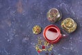 Red tea rooibos, hibiscus, karkade in glass cup and jars of dry tea leaf and petals on dark background. Herbal, vitamin, detox Royalty Free Stock Photo